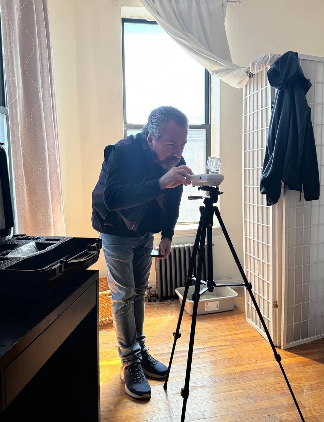 Tom Moore, the owner of Mold Testing LLC, setting up specialized mold testing equipment in a room with natural light